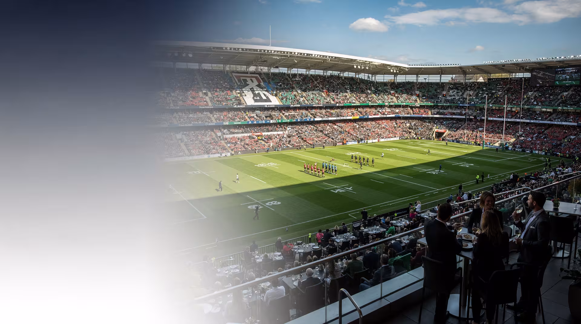 Packed rugby stadium viewed from a premium hospitality terrace