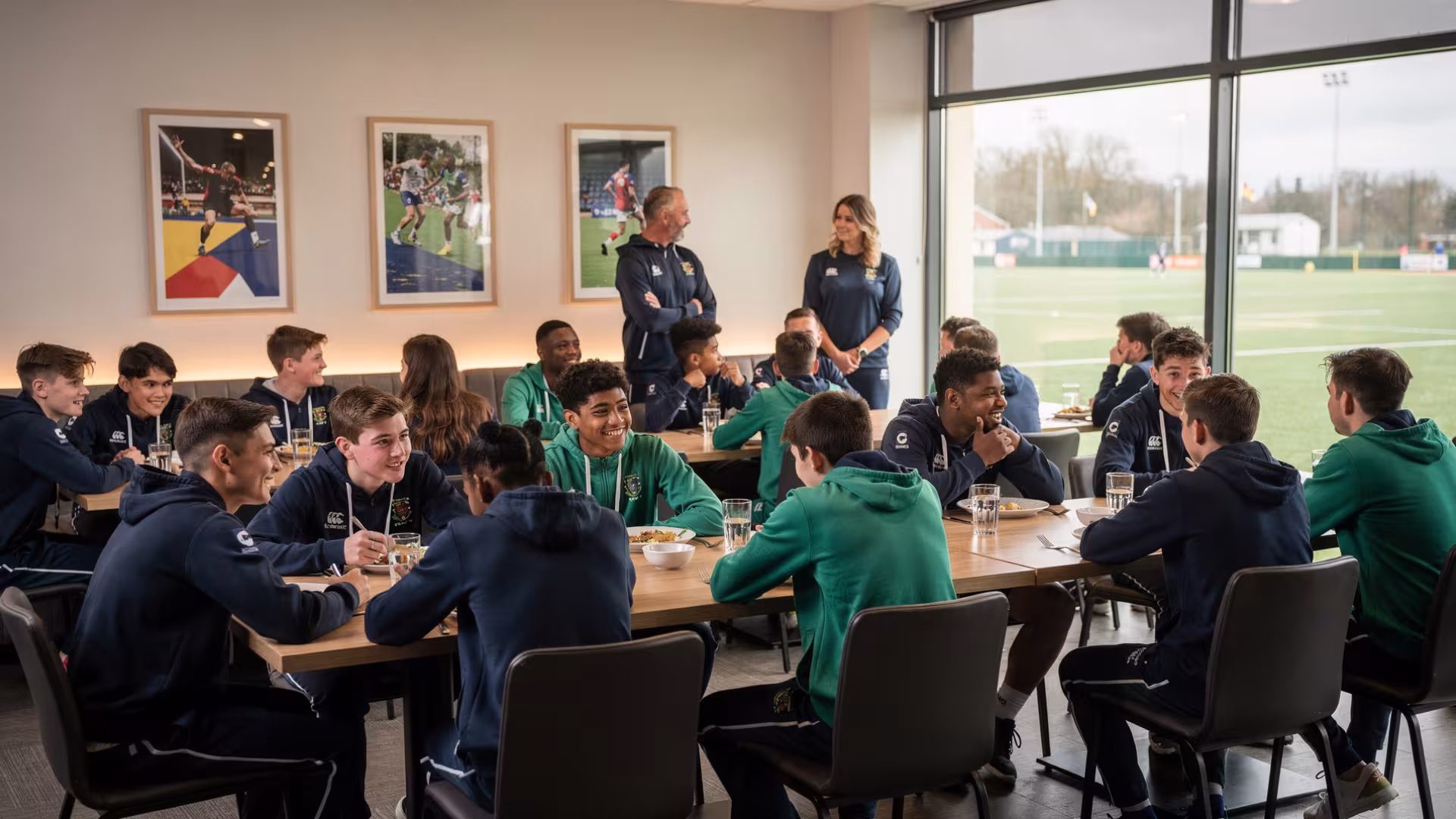 Youth rugby teams sharing post-match hospitality in a clubhouse